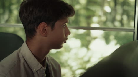 indian boy sitting school bus alone close up. teen schoolboy looking window.