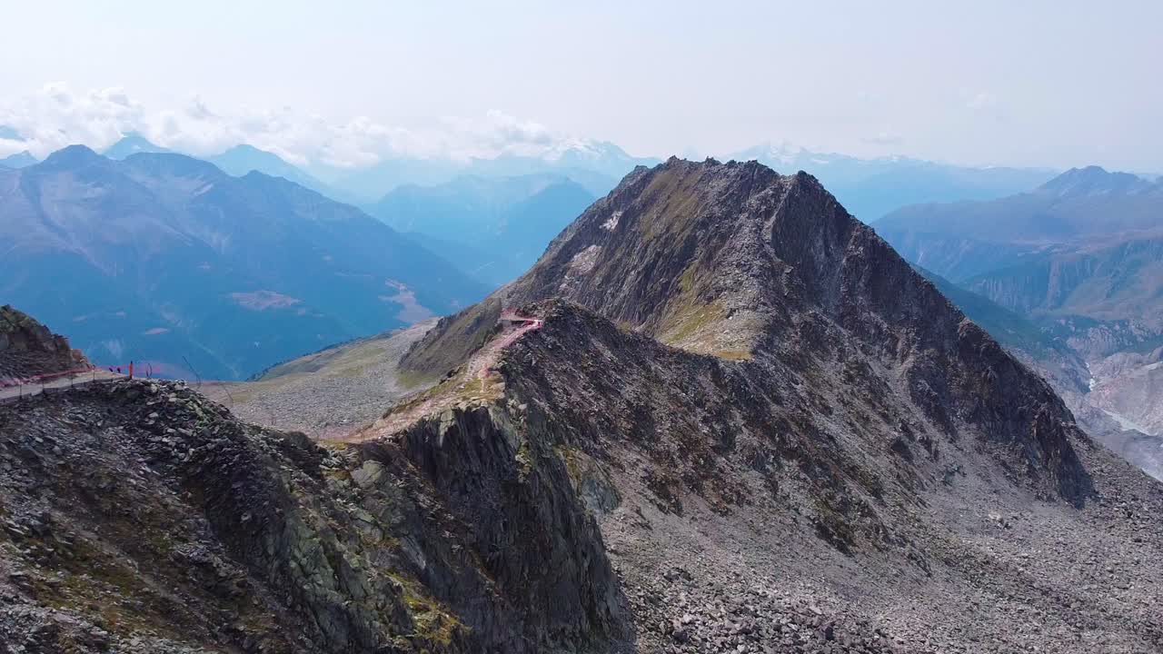Aerial view above swiss alps mountain range landscape during summertime, hiking trail in the mountains of Switzerland