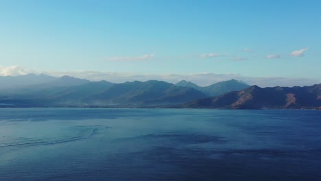 Friedliche-Meereslandschaft-Mit-Wunderschönen-Bergen-Tropischer-Inseln-Am-Horizont,-Tiefblaues-Meer-Unter-Hellem-Himmel,-Indonesien