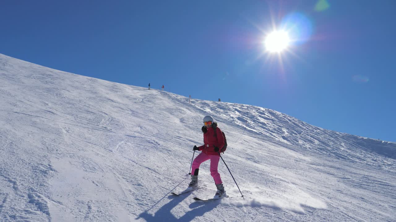 Sciatore che scende il pendio della montagna sollevando spruzzi di neve