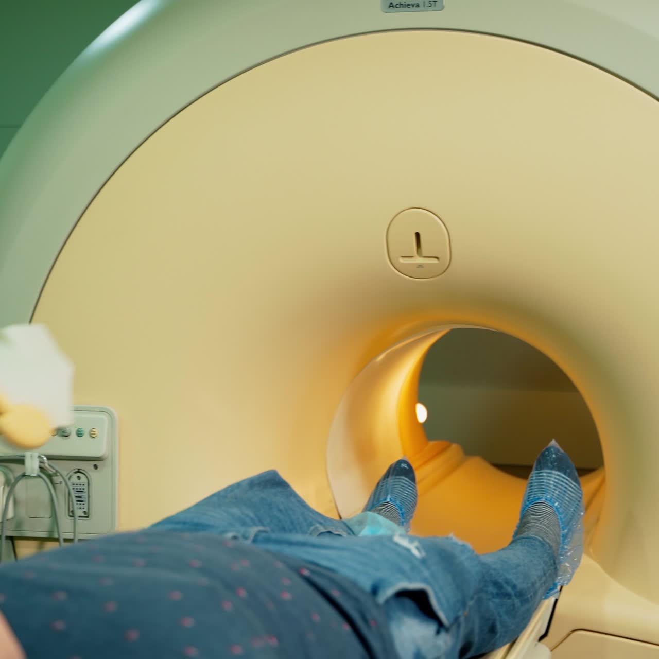 Nurse prepares patient for medical procedure. Male patient lying on a medical bed on the modern equipment background. Healthcare concept.