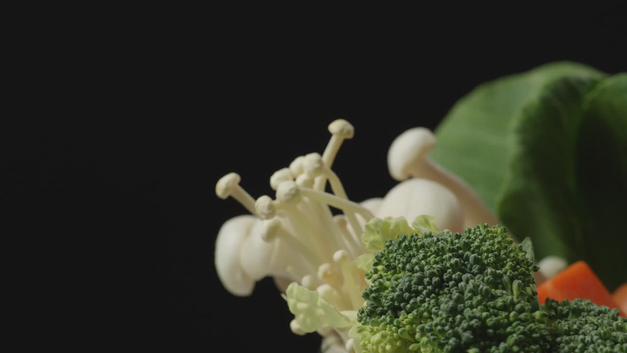 Close Up Of A Pot Of Shabu Ingredients Spinning Around On The Black Background