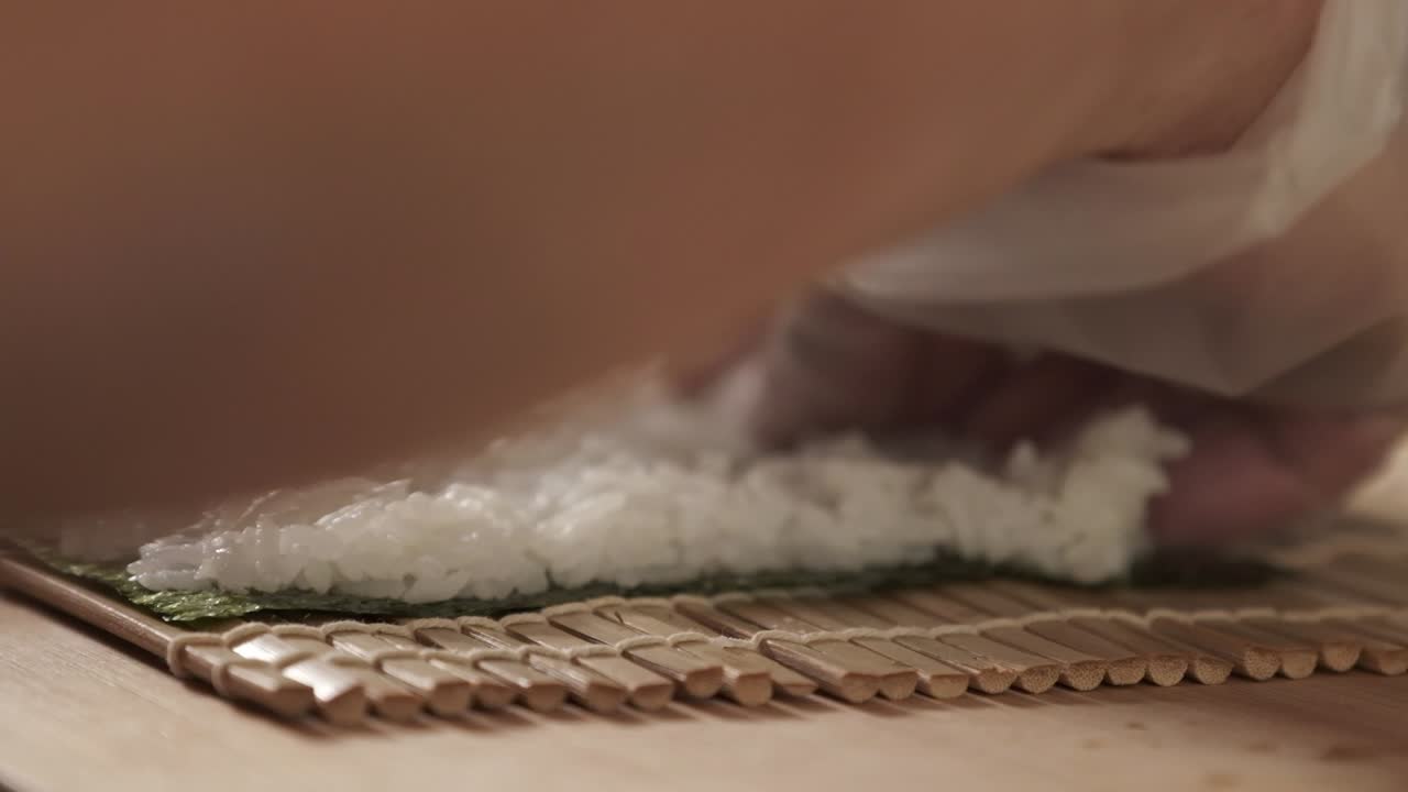 chef preparando rollos de sushi en la cocina