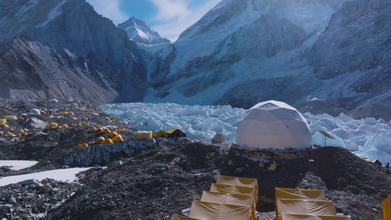 Drone view of Everest Base Camp with climbers’ tents, shining snow peaks, summit start points and signs of environment pollution during Nepal’s climbing season, Mount Everest lifestyle