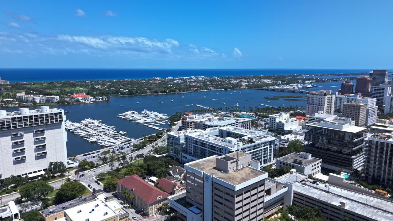 Pull out drone shot of West Palm Beach marina, harbor and cityscape during the day in Florida, USA