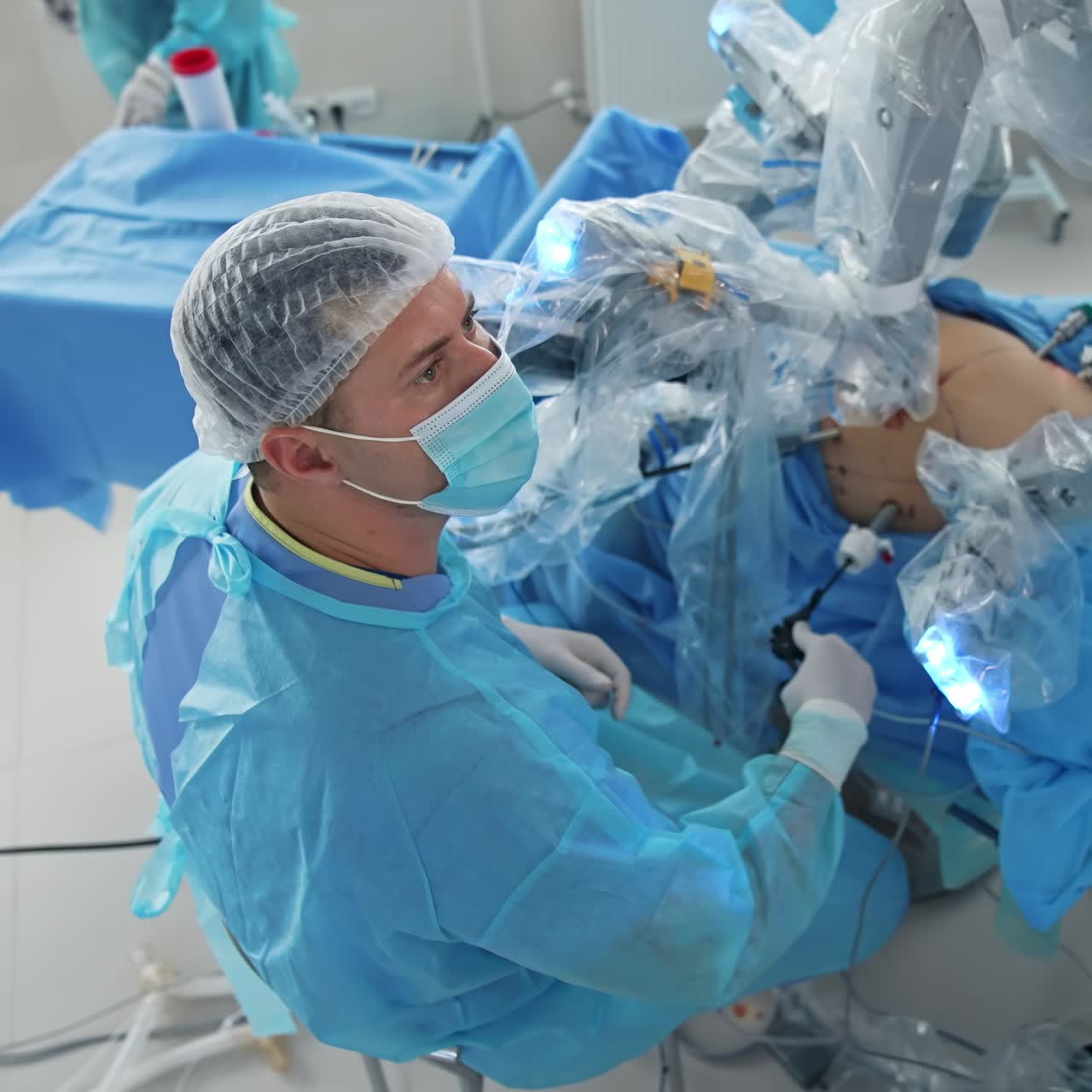 Surgical procedure with robotic technology equipment. Surgical machine arms in futuristic operating room doing minimal invasive surgery. Professional doctor with medical robot. Top view