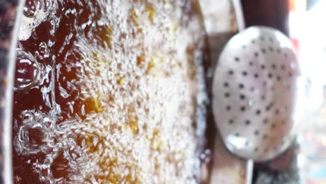 close-up of hot bubbling oil in a deep-frying pan