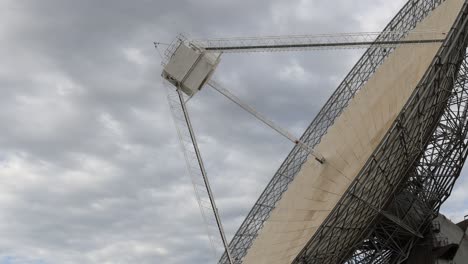 time-lapse of a large antenna rotating under a cloudy sky