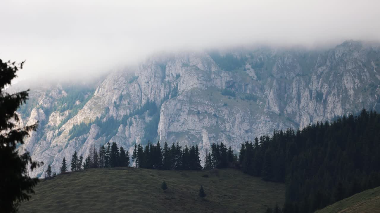 pico de la montaña rocosa envuelto con nubes y niebla
