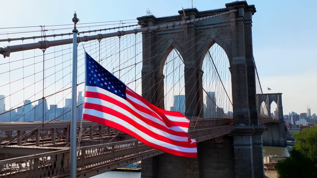Bandiera americana che sventola sul Ponte di Brooklyn con lo skyline di New York