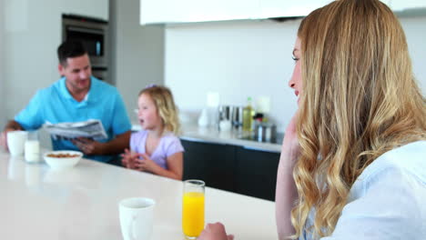 Madre-Hablando-Por-Teléfono-Mientras-La-Familia-Desayuna