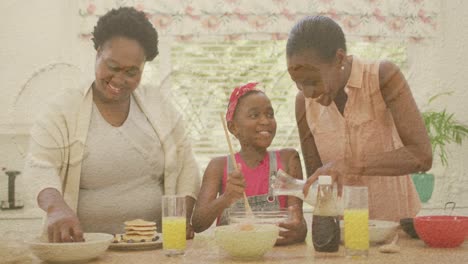 Sand-on-the-beach-against-african-american-grandmother,-mother-and-granddaughter-baking-together