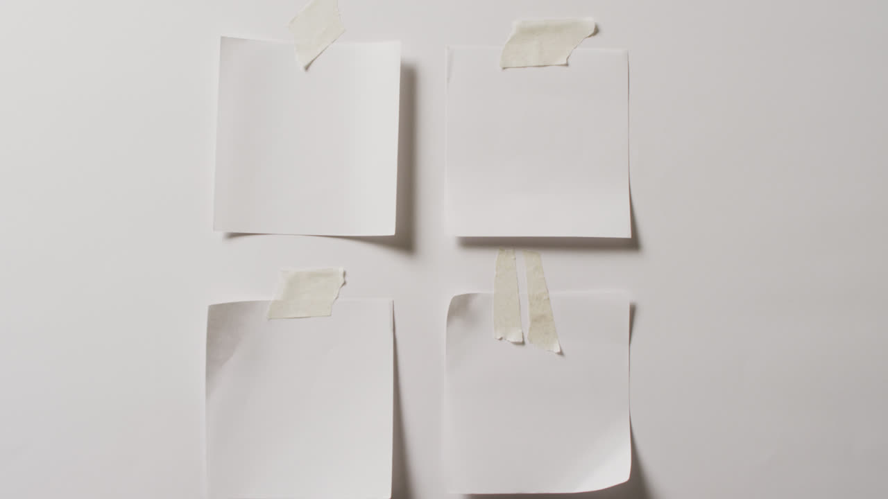 видео сближения четырех белых записок с копировальным пространством, прикрепленным к белому фону