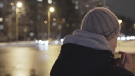 close-up of a young northern european man in winter clothes rubbing his hands together in the street