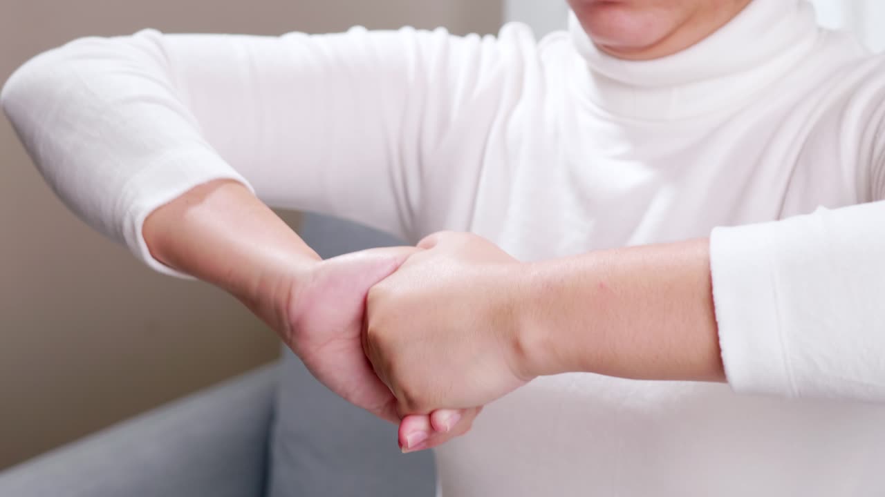 cerca de las manos de una mujer joven, haciendo un masaje de manos sola para calmar y relajar