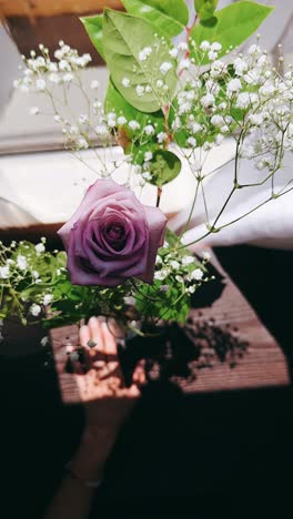purple rose and small white flowers arrangement