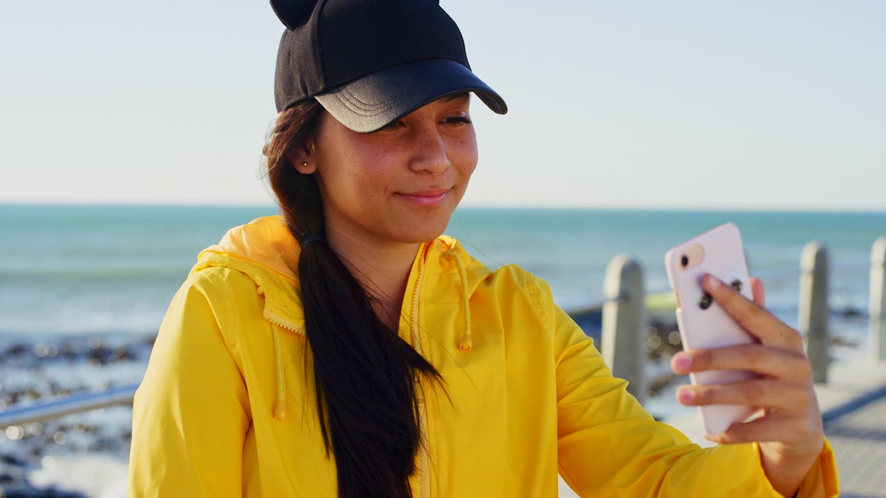 Young Woman Using Smartphone on Coastal Promenade