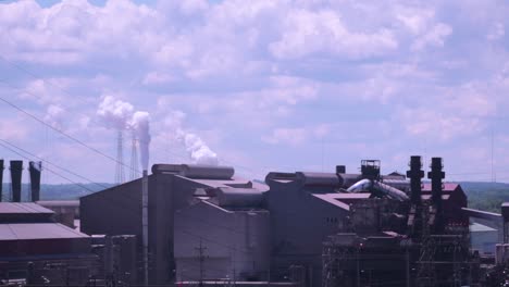 factories producing pollution in the air on a sunny day with blue skies