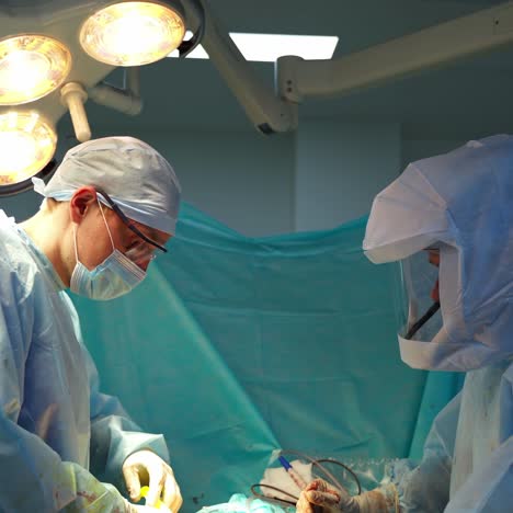 Medical workers in the hospital. Professional doctors in sterile uniform doing a surgery in the operating theater. Ending of pandemic.