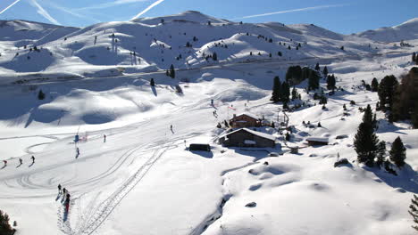 a serene view of a ski resort in the dolomites, featuring skiers enjoying the snowy slopes and a cozy cabin