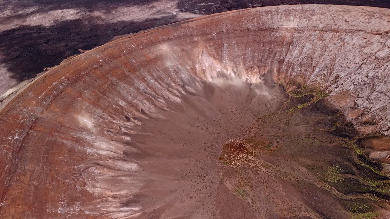 Impressive aerial drone footage of Caldera Blanca, the largest volcanic crater in Lanzarote measuring approximately 1,200 meters in diameter. Canary Islands, Spain.