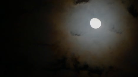 las nubes pasaron a través de la luna llena en una noche nublada