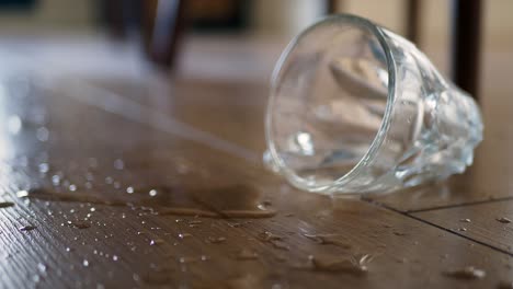 spilled water and broken glass on wooden floor