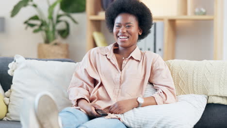 laughing woman with afro watching tv