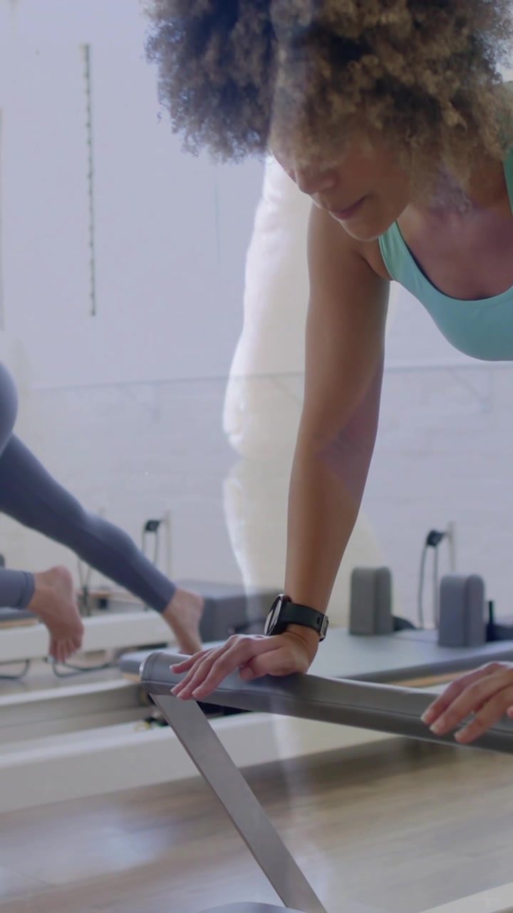 Women exercising on reformer machines with digital data overlay animation