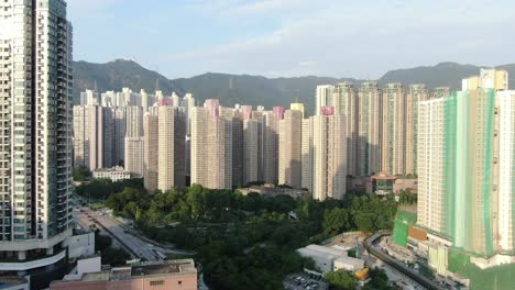 Mega-residential-buildings-in-downtown-Hong-Kong-and-Lion-rock-mountain-ridge-in-the-background,-Aerial-view