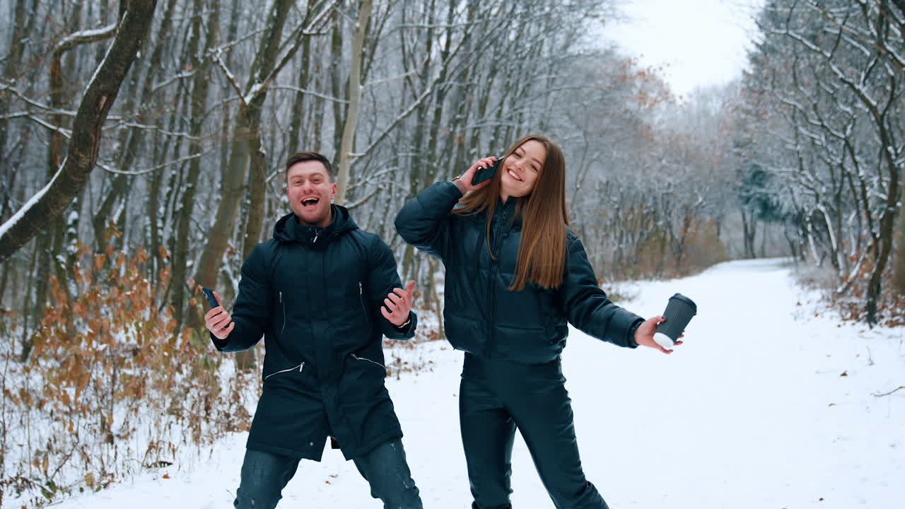 Happy rejoicing couple jumping happily outdoors. People are cheering having received good news.