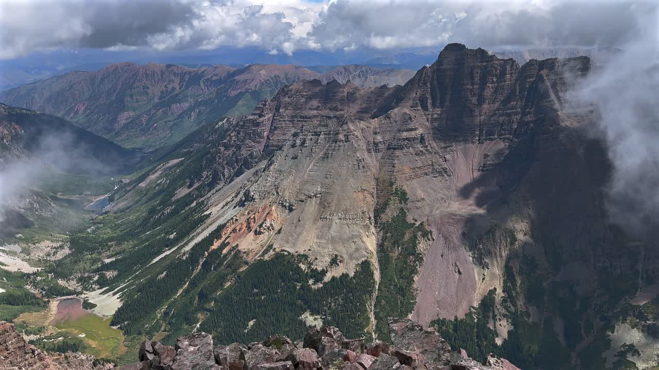 Pyramid Peak Aspen Snowmmass Maroon Peak Lake Maroon Bells Wilderness hiking fourteener Colorado summer aerial drone clear sunny fog valley Elk Range Rocky Mountains rugged terrain pan left motion