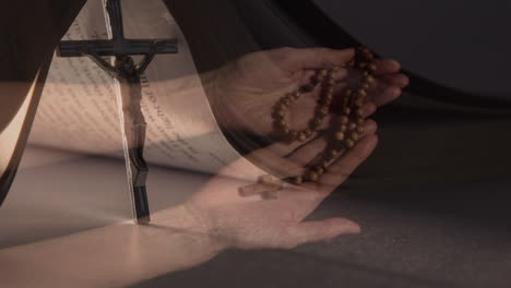 animation of caucasian woman praying with rosary over cross and bible