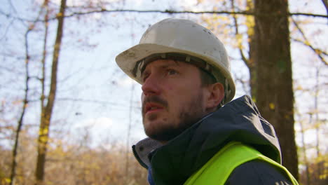 primer plano en cámara lenta, trabajador con ropa de protección observando el bosque