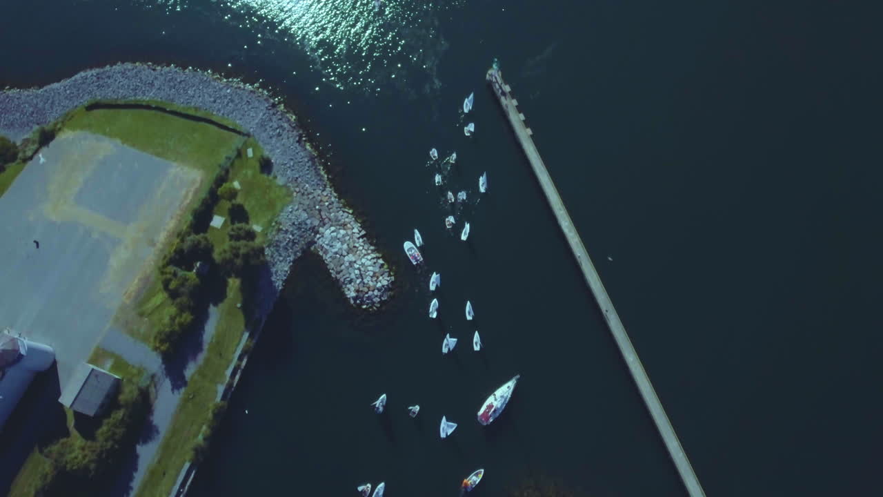 Wide drone view of boats leaving port, boats sailing. Wide aerial view of boats at sailing contest, Cork, Sail Kingston and Ontario Sailing.