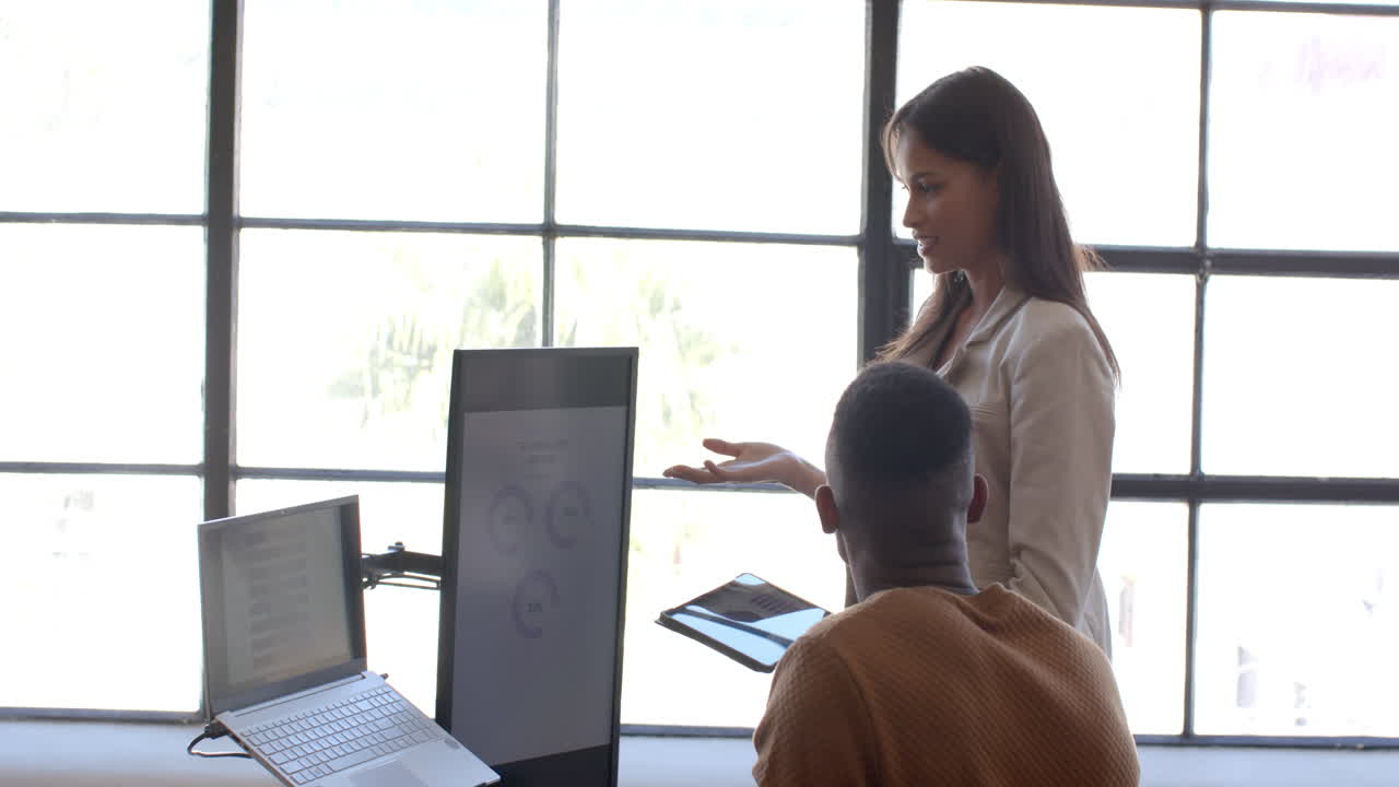 Business meeting, woman presenting data on screen to colleague with laptop