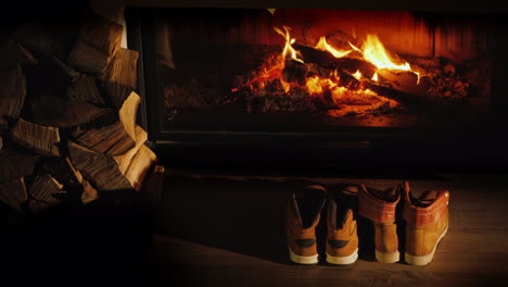 botas de invierno para hombres y mujeres secas cerca de la chimenea romántica noche de invierno