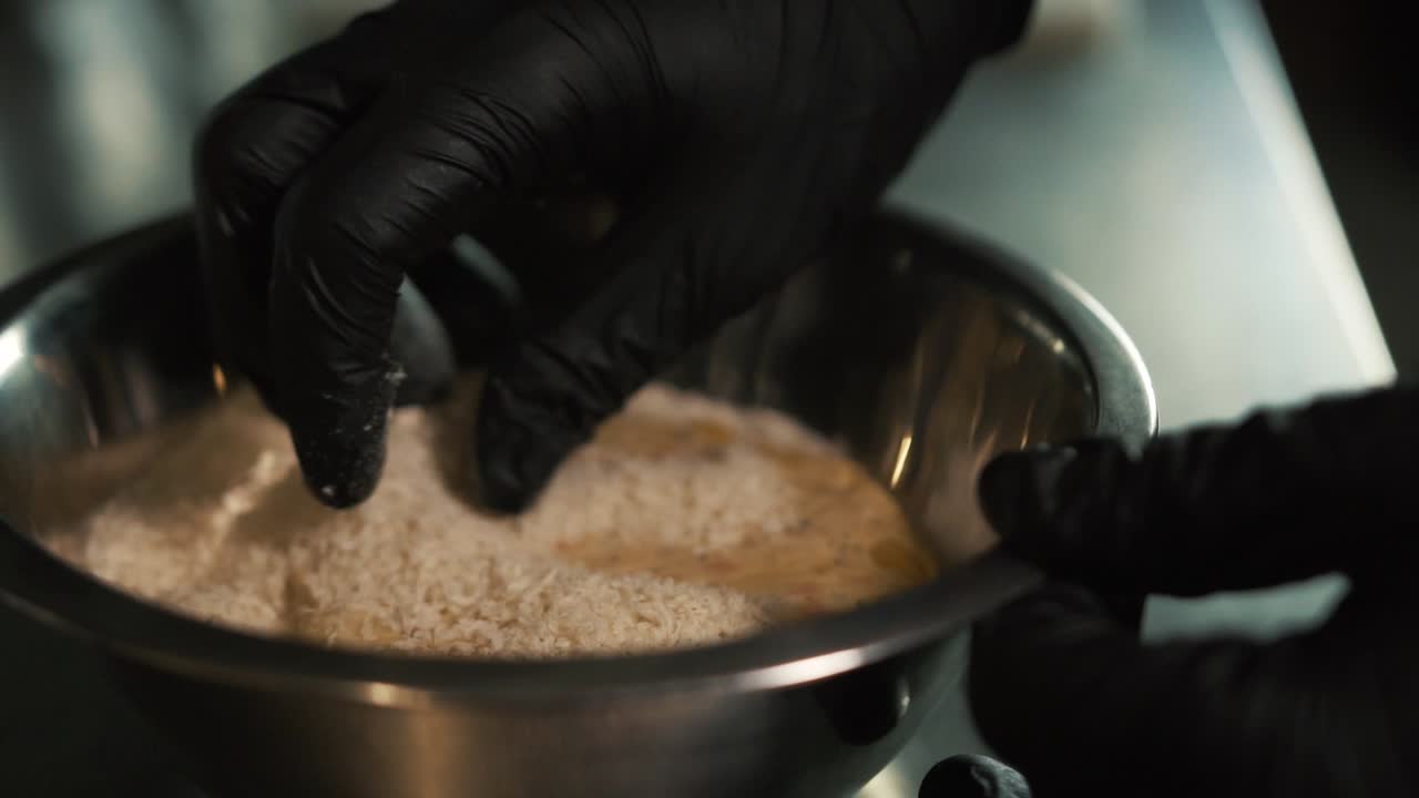 Hands with black gloves prepare burger. Slow-motion and close up