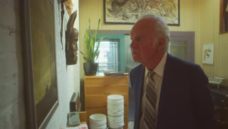 a man looking at artwork in an indoor setting