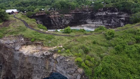 Antena-Que-Se-Acerca-A-La-Playa-Rota-Que-Muestra-Un-Arco-Con-Una-Pequeña-Cala-Increíble-En-Nusa-Penida