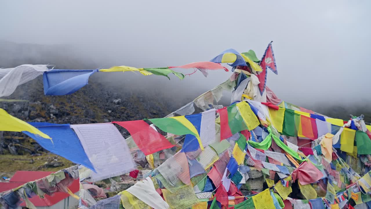 네팔의 산에서 불교 기도 발, 히말라야에서 안개 속에 있는 다채로운 티베트 기도발, 안나푸르나에서 바람에 날아다니는, 자연에서 불교의 다채로운 종교적 상징.