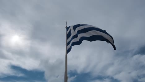 slow motion of greek flag rippling on the wind against cloudy sky