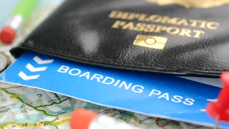 travel essentials: diplomatic passport, boarding pass, and map with pins
