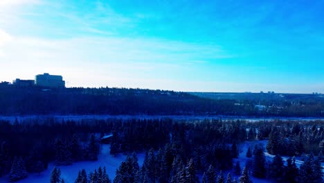 aerial flyover closeup over snow covered pine fir trees overlooking cross country skiing tracks by pavilion repurposed from a golf course by river divide in between park and the university campus 2-2