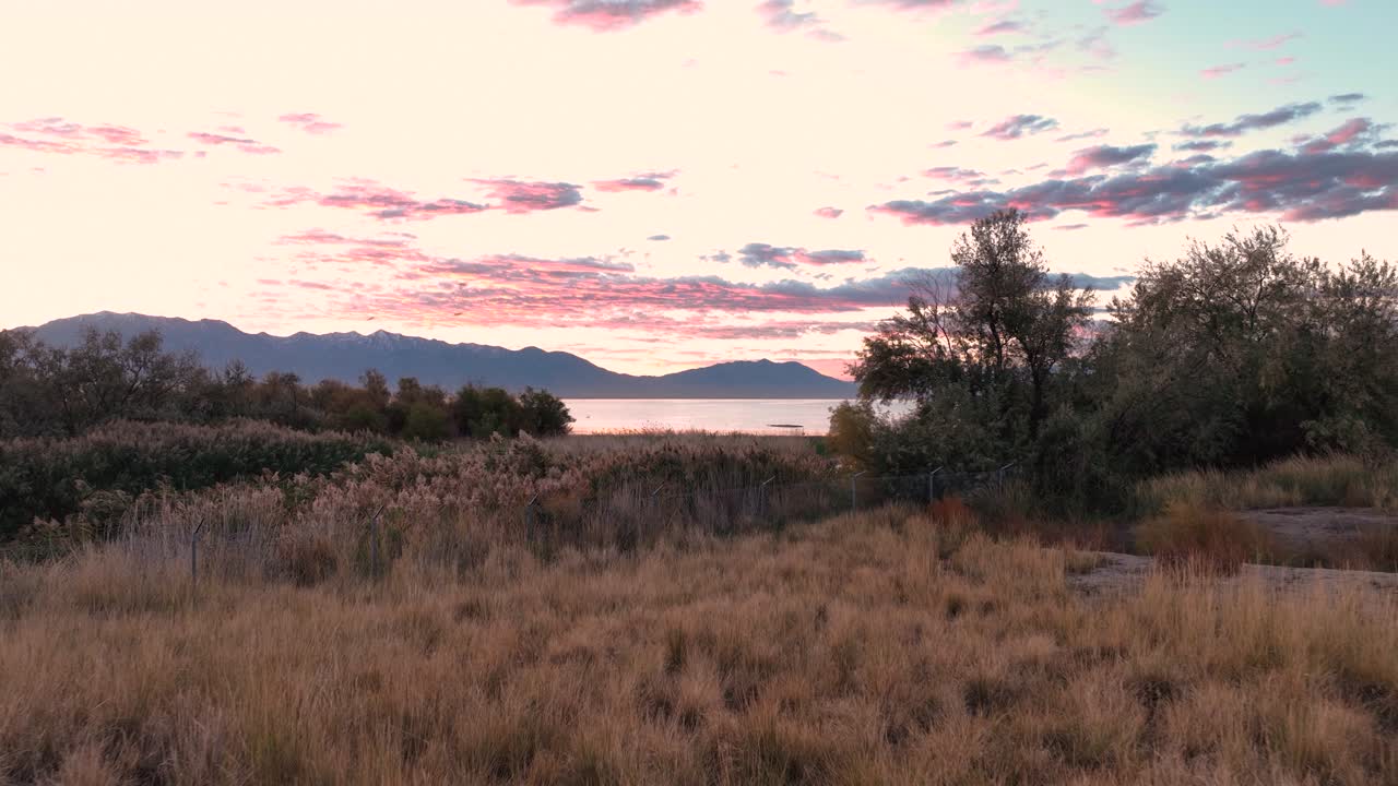 Aerial Flyover Reveal Of Colorful Sky Reflections On The Jordan River During Sunrise At Utah Lake, USA