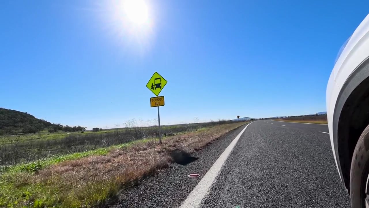 Matala kuvakulma valkoisesta ajoneuvosta matkalla pitkin australialaista maaseututietä Nombissa.