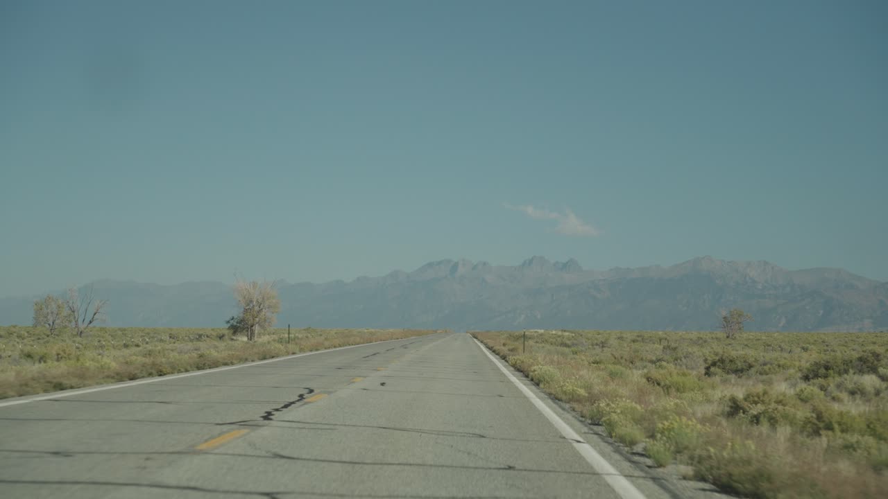 A road through the desert landscape with mountains in the background