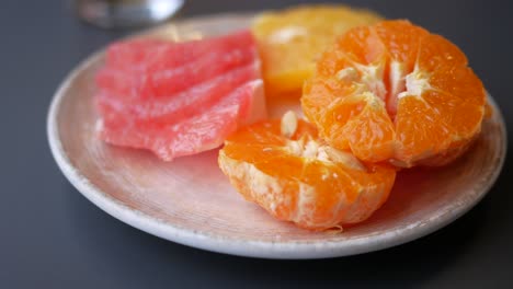 pomelo cortado y naranjas en un plato