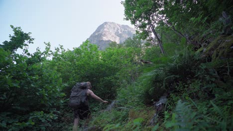 Caucasian-Backpacker-With-A-Dog-Climbing-On-The-Forest-Mountains-Of-Katthammaren-In-Norway