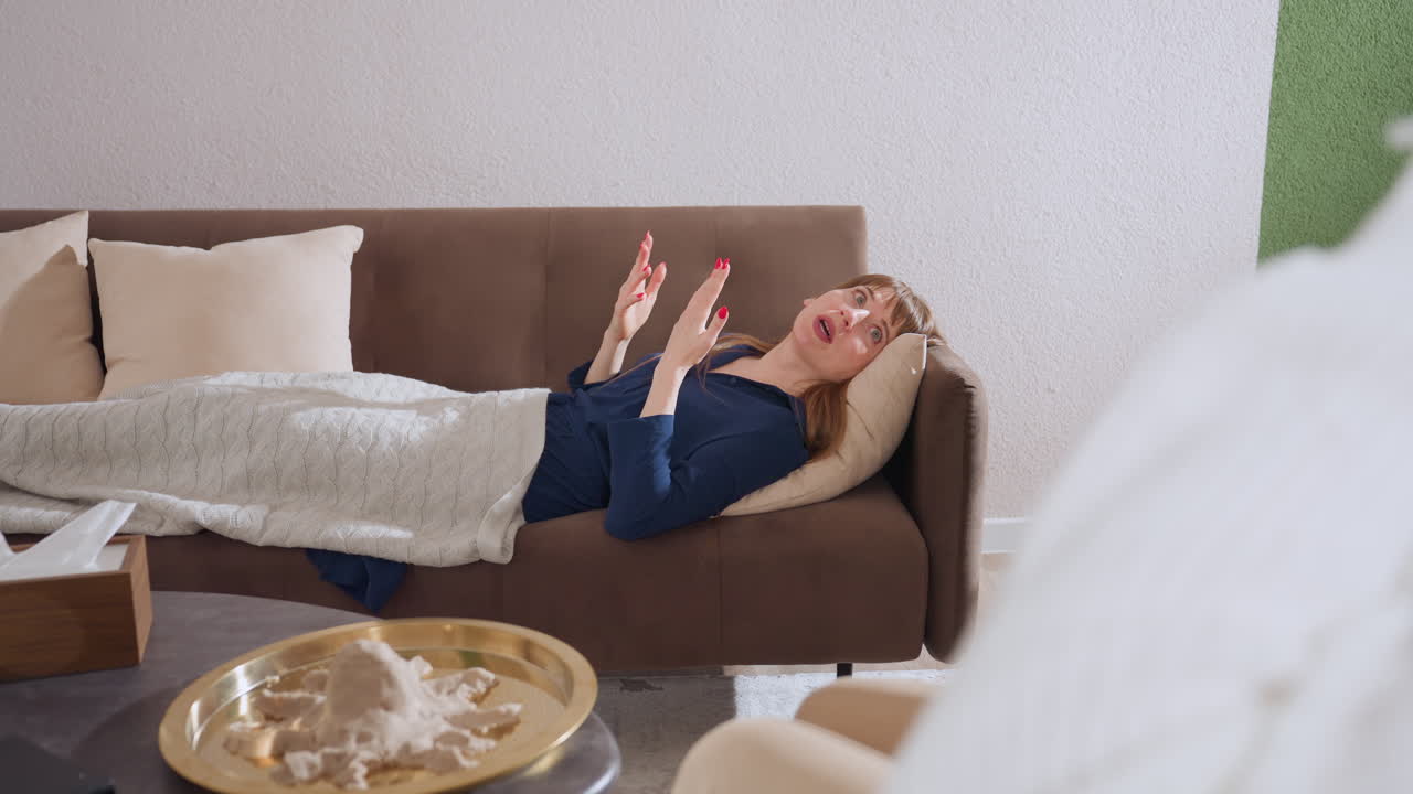 Individual lying faced up on sofa speaking expressively using hand gestures in therapy session, cozy therapeutic environment, relaxed atmosphere, openly communicating emotions comfortably